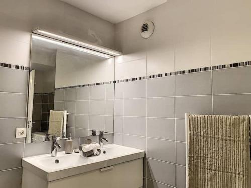 une salle de bain blanche avec un lavabo et un miroir dans l'établissement Bel appartement spacieux Sainte-Maxime Centre ville, à Sainte-Maxime