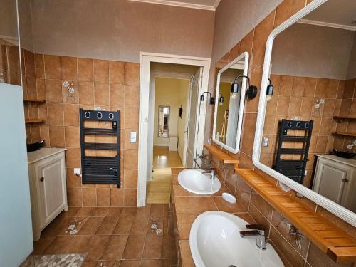 une salle de bain avec deux lavabos et deux miroirs dans l'établissement maison avec studio independant dans le centre de soulac - 5306, à Soulac-sur-Mer
