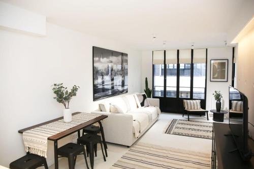 un salon avec un canapé blanc et une table dans l'établissement Elegance et confort pres du Marais Cosy - 4P, à Paris