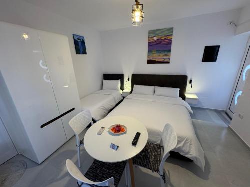 a bedroom with a bed and a table and chairs at Private Villa Aras 2 - Luxury & Elegance Apartments in Vlorë