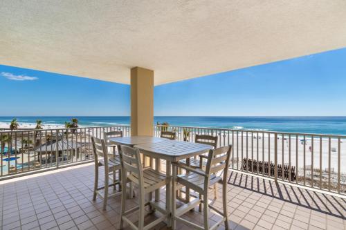 ein Tisch und Stühle auf einem Balkon mit Blick auf den Strand in der Unterkunft Romar Place Condos in Orange Beach