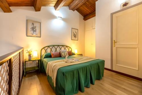 1 dormitorio con 1 cama con colcha verde en SARDINIA RE - Loft Antica Italia, en Sassari