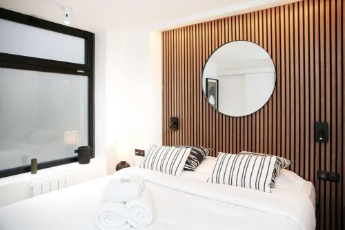 une chambre avec un grand lit blanc et un miroir dans l'établissement Espace et Confort en Famille - Marais a Cote - 6P, à Paris