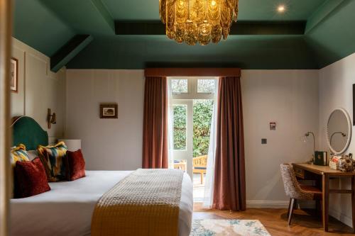 a bedroom with a bed and a window and a chandelier at Coach & Horses Hotel in London