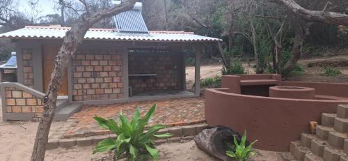 a small brick building with a roof on top at East Africa Safaris in Chizavane