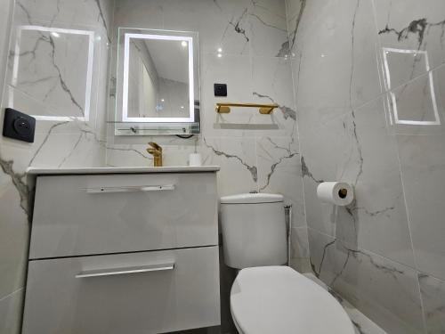 une salle de bain avec toilettes, lavabo et miroir dans l'établissement Highstay ARC de TRIOMPHE, à Paris