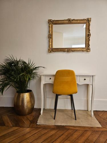 une chaise jaune assise à côté d'un bureau avec miroir dans l'établissement Highstay ARC de TRIOMPHE, à Paris
