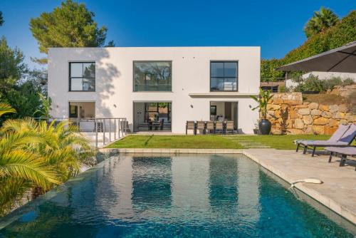 une maison avec une piscine devant une maison dans l'établissement 9m of center, Cannes high luxe Villa Mila 6bdrooms heated pool Sauna cinema fitness, à Vallauris