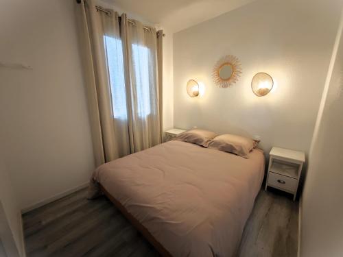 une petite chambre avec un lit et une fenêtre dans l'établissement Villa Port Vénus Dolce Vita, au Cap d'Agde