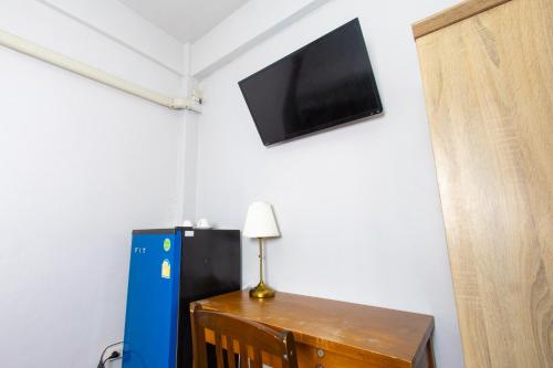 a room with a refrigerator and a tv on the wall at TOM CAFE MY House in Thung Maha Mek