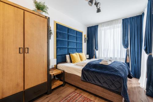 a bedroom with a bed and a blue headboard at Dandelion Loft Apartment in Budapest