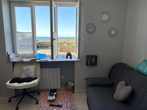 - un salon avec un canapé, une table et des fenêtres dans l'établissement La Rose des Sables, à Tréffiagat