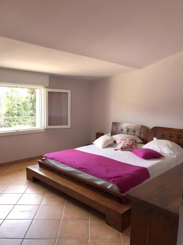 une chambre avec un grand lit avec des draps violets dans l'établissement Mas de la Crozette, à Monteux