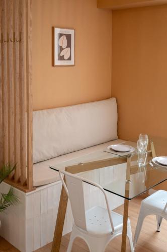 une salle à manger avec une table en verre et un canapé dans l'établissement Appartement une chambre sur la place Sébastopol, à Lille