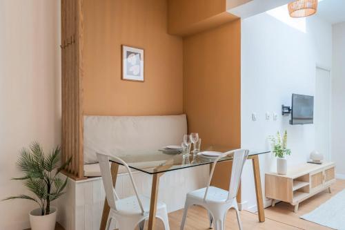 une salle à manger avec une table en verre et deux chaises dans l'établissement Appartement une chambre sur la place Sébastopol, à Lille