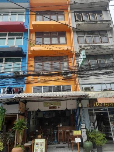a colorful building with a restaurant in front of it at TOM CAFE MY House in Thung Maha Mek