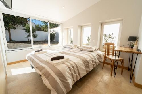 une chambre avec un lit, un bureau et des fenêtres dans l'établissement Propriété 8 suites avec jardin, à Challans