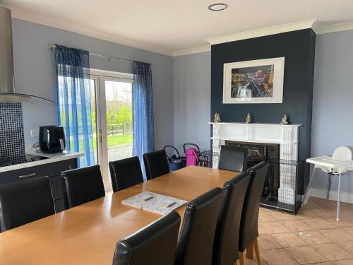 a dining room with a table and chairs and a fireplace at Ballygarrett Holiday Home by Trident Holiday Homes in Ballygarrett