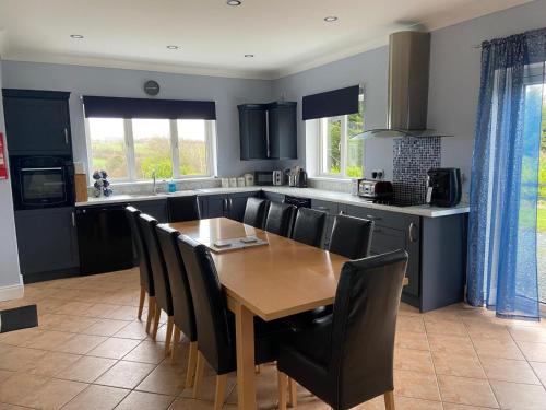 a kitchen and dining room with a wooden table and chairs at Ballygarrett Holiday Home by Trident Holiday Homes in Ballygarrett