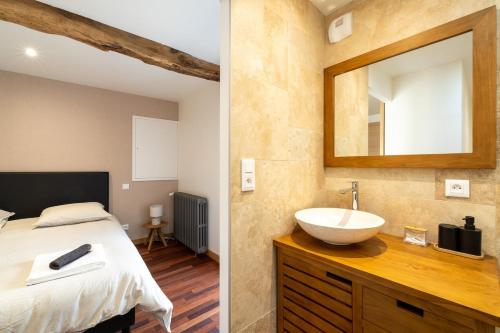 une chambre avec un lit, un lavabo et un miroir dans l'établissement Propriété 8 suites avec jardin, à Challans