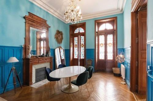 une salle à manger avec des murs bleus et une table et des chaises dans l'établissement Charme et confort, à Avignon