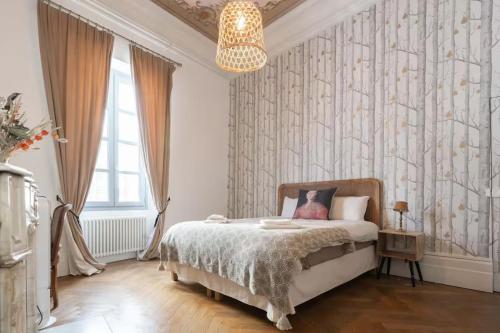 une chambre avec un lit et un lustre dans l'établissement Charme et confort, à Avignon