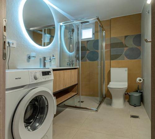 a bathroom with a washing machine and a shower at GREEN n' BLUE apartments in Kalamaki