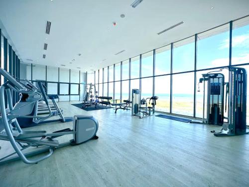 a gym with cardio equipment in a large room with windows at Imperio Residence Melaka in Melaka
