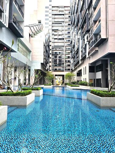a large swimming pool in a building with tall buildings at Imperio Residence Melaka in Melaka