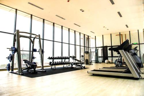 a gym with treadmills and machines in a room with windows at Imperio Residence Melaka in Melaka