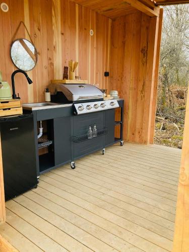 - une cuisine extérieure avec une cuisinière dans une cabine dans l'établissement Tente luxe vue Etang avec jacuzzi 4, à Le Vigeant