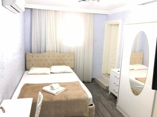 a bedroom with a large bed and a mirror at Antalyanın kalbinde teraslı odalar in Antalya