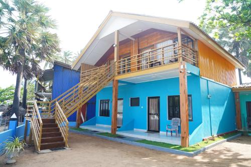 a house with a blue facade with a staircase at Golden Beach Hotel & Restaurant in Trincomalee