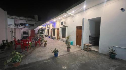 a building with a patio with chairs and potted plants at Kanak Bihari Yatri Niwas, 100 Meter Ram Ki Paidi, Saryu River in Ayodhya