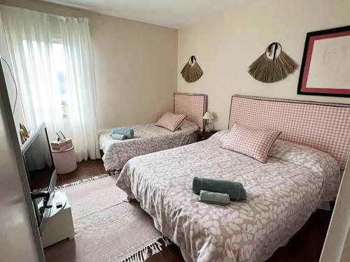 a bedroom with two beds and a tv in it at Increible casa de campo, 5 DORM, MARCO INCOMPARABLE in Pareja