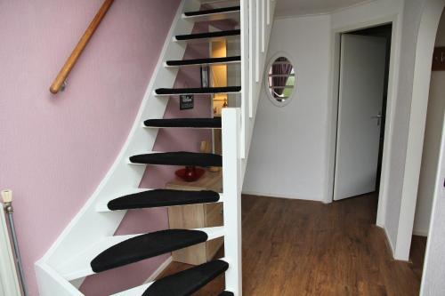 a staircase in a house with black treads at Spotvogel I Vacation Home in Zwiggelte