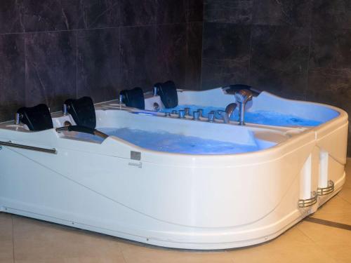 a white bath tub with blue water in it at Novotel Jazan in Jazan