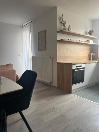 a living room with a table and a kitchen at Apartman Vrućica view in Teslić