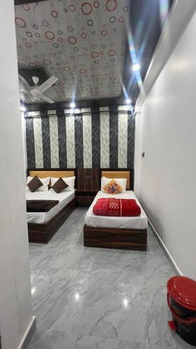 a bedroom with two beds in a room at Kanak Bihari Yatri Niwas, 100 Meter Ram Ki Paidi, Saryu River in Ayodhya