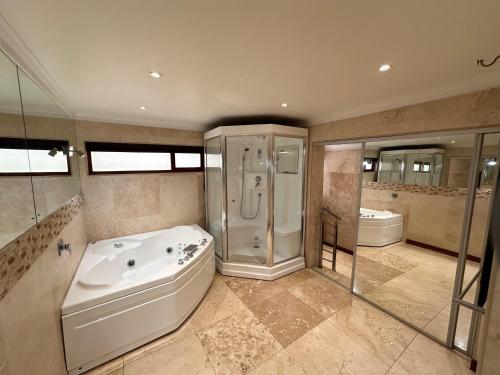 Un baño grande con bañera y ducha. en Concordia Boutique Venue, en Midrand