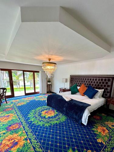 a large bedroom with a large bed and a chandelier at Concordia Boutique Venue in Midrand