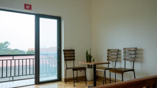 a room with two chairs and a table and a balcony at Tam Coc Gold Smile Homestay in Vũ Lâm