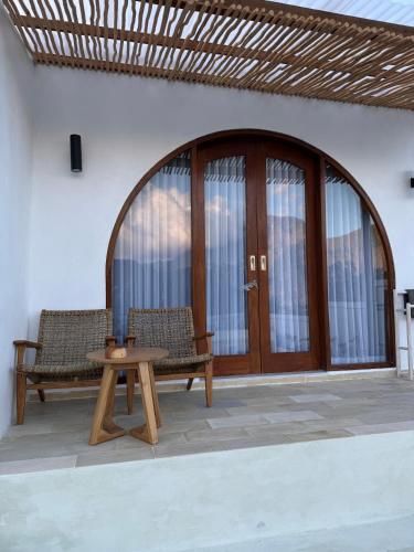 a patio with two chairs and a table and a door at Bali Astetic Villa and Hot Spring in Kintamani