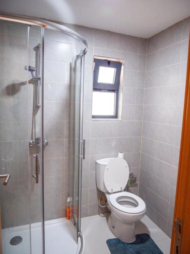 a bathroom with a toilet and a glass shower at Appartement moderne avec vue sur la mer in Praia