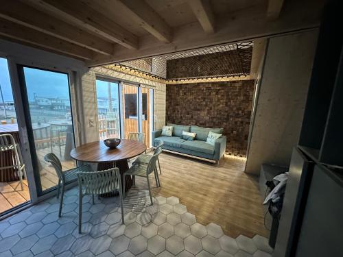 un salon avec une table, des chaises et un canapé dans l'établissement Chalet Linoli, à Gruissan