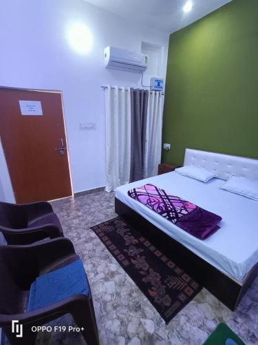 a bedroom with a bed and a green wall at Kanak Bihari Yatri Niwas, 100 Meter Ram Ki Paidi, Saryu River in Ayodhya