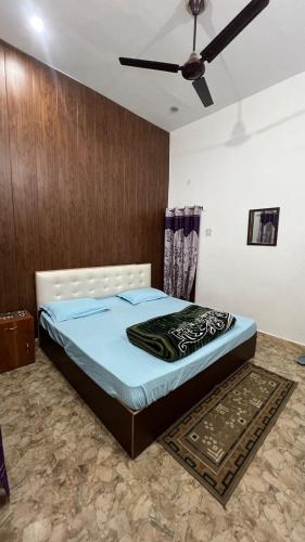 a bedroom with a bed with a ceiling fan at Kanak Bihari Yatri Niwas, 100 Meter Ram Ki Paidi, Saryu River in Ayodhya