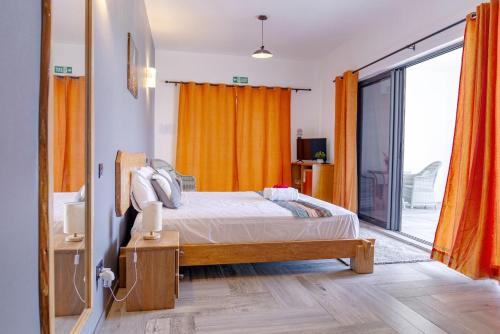 a bedroom with a bed and a large window at Villa Soleil de L'Est in Petit Brûlé
