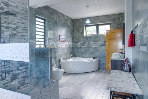 a large bathroom with a tub and a sink at Villa Soleil de L'Est in Petit Brûlé