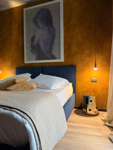 a bedroom with a bed with a picture on the wall at KUDETÀ SUITE in Campobasso